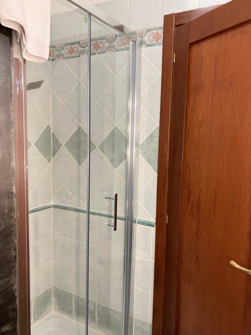 Moderna cabina doccia in vetro con piastrelle a motivo diamante nell'appartamento Fairome Fleming B, Roma