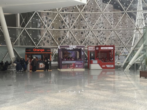 Terminal aérien moderne avec bornes télécom à Essaouira, Maroc, plafond géométrique et boutiques commerciales