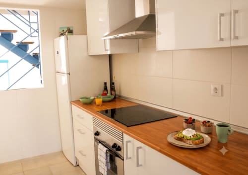 Moderne Küche im Casa del Sol Cottage in Morro Jable mit Holzarbeitsplatten, weißen Schränken, Herd und Meerblick