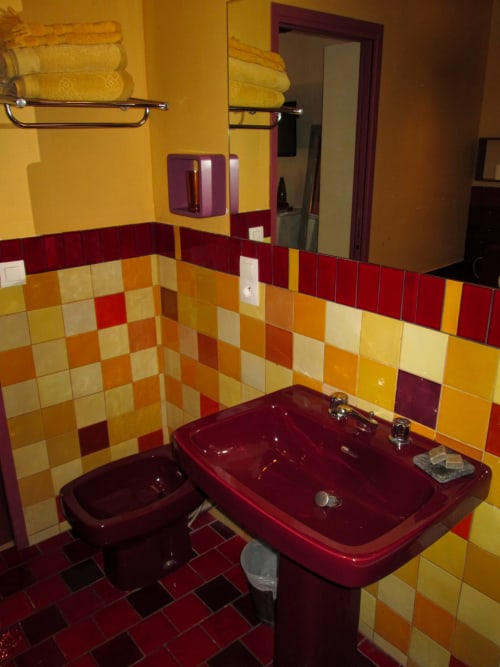 Colorful retro bathroom at Clos Bb in Saint-Cyr sur Mer with burgundy fixtures and checkerboard tiles