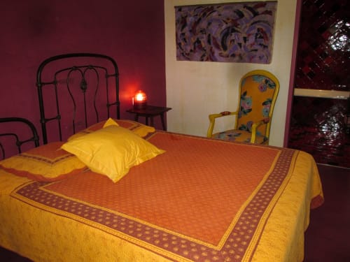 Chambre éclatante au Clos B&B à Saint-Cyr sur Mer avec couvre-lit orange, oreillers jaunes et murs bordeaux