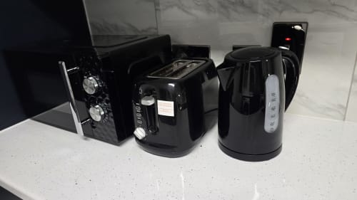 Black kitchen appliances including toaster, kettle, and microwave at Entrepreneur Stays cottage in Stafford