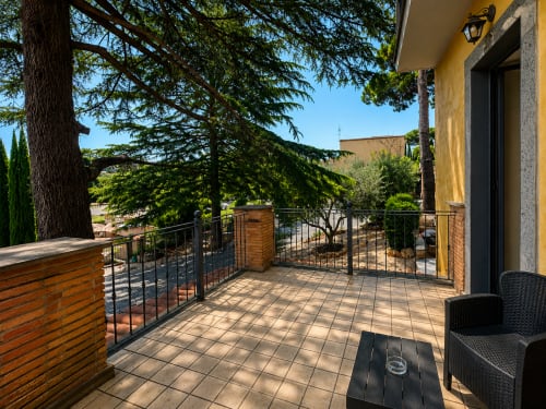 Balcone soleggiato con vista sul giardino al Green Hotel Poggio Regillo di Frascati, con pavimento in cotto, moderna ringhiera e