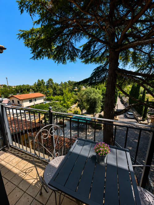 Vista dal balcone di Green Hotel Poggio Regillo a Frascati con giardino, sedute e antica quercia che si affaccia sulla campagna