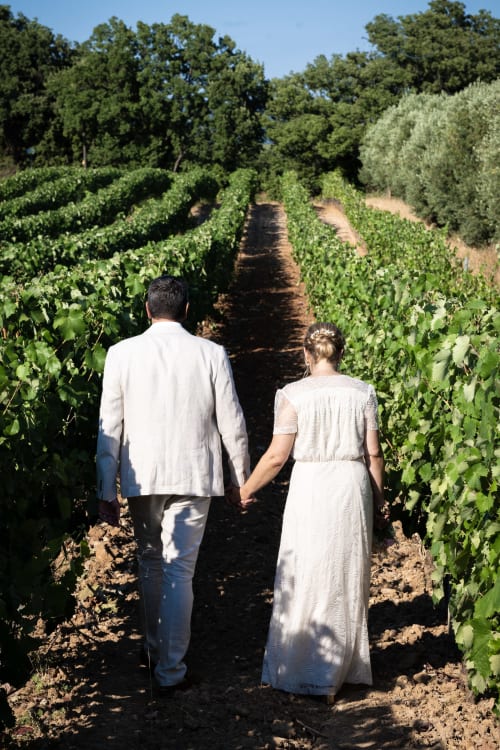 Couple se tenant par la main dans les rangées de vignes au domaine viticole Clos Bb à Saint-Cyr sur Mer, France