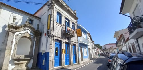 Colorful blue-doored historic building on charming street in Caminha, Portugal, home to Bom Caminha hostel