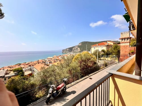 Vista dal balcone della costa di Finale Ligure e i tetti in terracotta dell'appartamento Welcome Holiday con vista mare