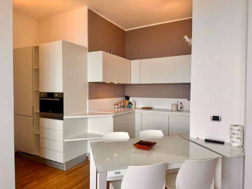 Moderna cucina e sala da pranzo dell'appartamento Il belvedere a Welcome Holiday, Finale Ligure con arredamento bianco e vista mare