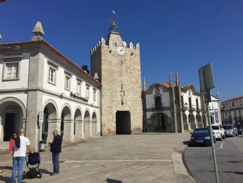 Historic town square in Caminha, Portugal featuring a stone church tower and colonial architecture near Bom Caminha hostel