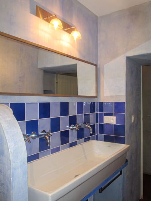 Bagno moderno presso Clos Bb con piastrelle a scacchi blu, lavabo bianco, specchio a parete e doppi applique