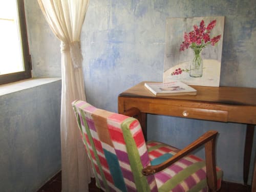 Accogliente angolo studio al Clos BB Saint-Cyr sur Mer con arredamento in legno, sedia colorata e opera d'arte con fiori rossi in vaso di vetro