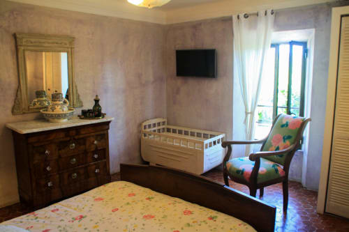 Camera accogliente a Clos Bb a Saint-Cyr sur Mer con letto, culla, cassettone in legno e porte-finestre sul balcone