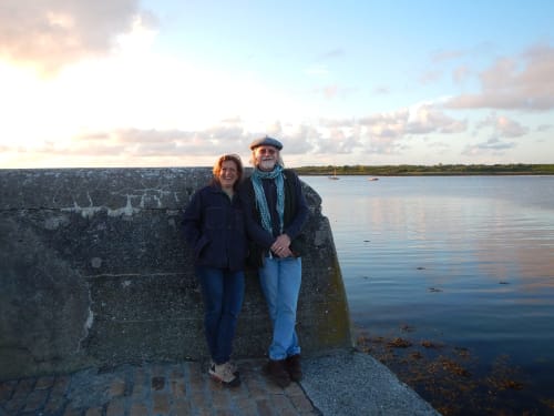 Couple posing by stone waterfront wall in Caminha, Portugal near Bom Caminha hostel