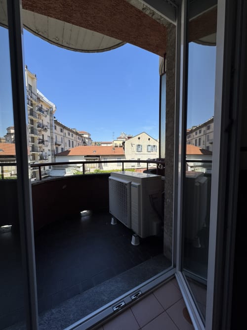 Vista dal balcone della Suite Porta Romana Milano con climatizzatore e skyline cittadino di edifici residenziali
