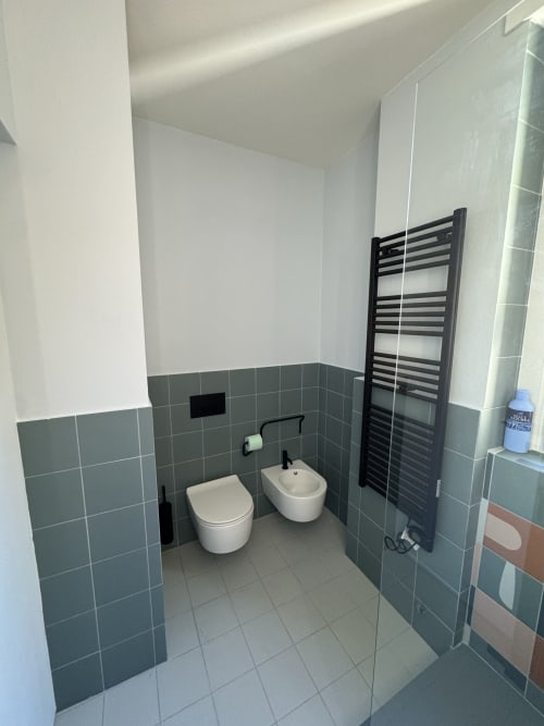 Bagno moderno nella Suite Porta Romana Milano appartamento 204 con doppi wc, scaldasalviette nero, piastrelle grigie e