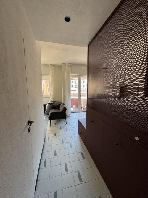Corridoio della Suite Porta Romana Milano, appartamento 204, che conduce al balcone con arredamento moderno in scuri toni