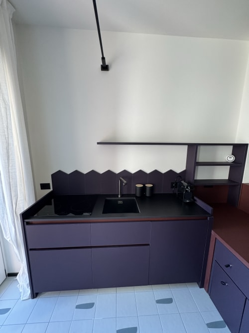 Angolo cottura moderno nella Suite Porta Romana Milano, appartamento 204, con mobili scuri, lavello nero e design minimalista