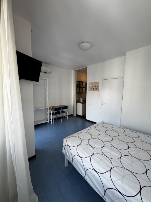 Luminoso monolocale presso Porta Romana Suite Milano con letto, TV, scrivania e angolo cottura