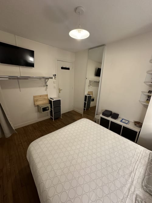 Chambre moderne à la Villa des Palmiers avec lit queen, murs blancs, parquet et rangements intégrés à Villeneuve-sur-Lot
