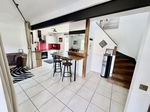 Cuisine ouverte et salle à manger contemporaines à la Villa des Palmiers B&B, avec crédence rouge, bar en bois et escalier