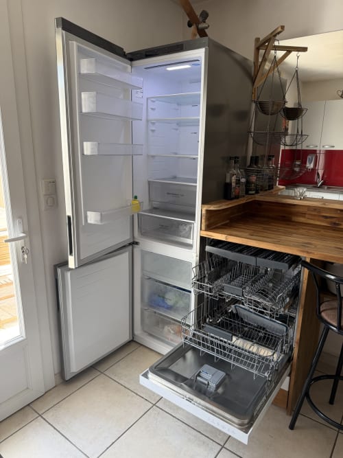 Cuisine moderne à la Villa des Palmiers B&B avec réfrigérateur ouvert et lave-vaisselle