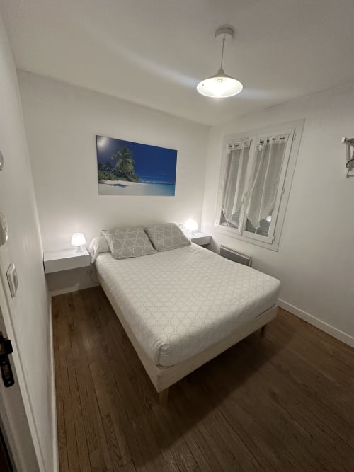 Chambre moderne à la Villa des Palmiers avec lit queen-size, luminaire suspendu et décoration bord de mer à Villeneuve-sur-Lot