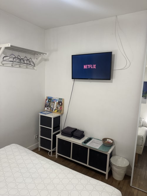 Chambre avec téléviseur mural affichant Netflix, rangements et lit à la Villa des Palmiers, Villeneuve-sur-Lot