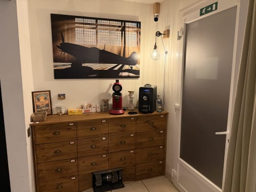 Chambre de la Villa des Palmiers avec commode vintage en bois, œuvre d'art silhouette d'avion et équipements modernes