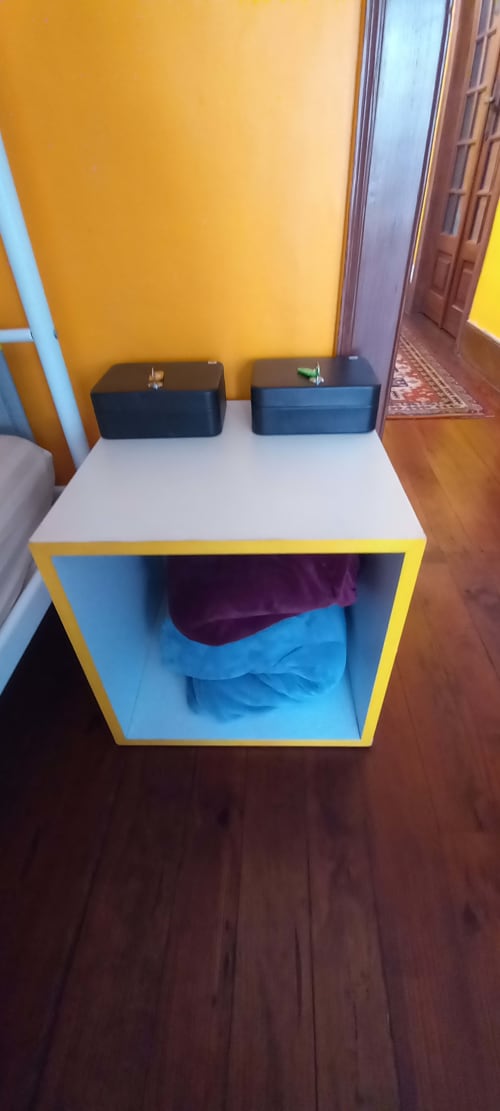 Estante colorida no quarto dormitório feminino da pousada Bom Caminha em Caminha, Portugal com interior azul e moldura amarela
