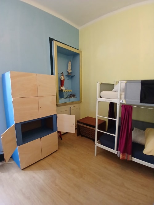 Quarto de dormitório feminino na pousada Bom Caminha em Caminha com beliches, armazenamento em madeira e pisos de madeira dura