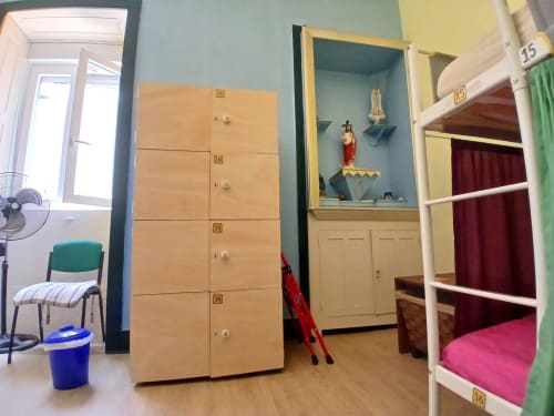 Quarto dormitório feminino da pousada Bom Caminha em Caminha com armários numerados, beliches, altar religioso e áreas compartilhadas