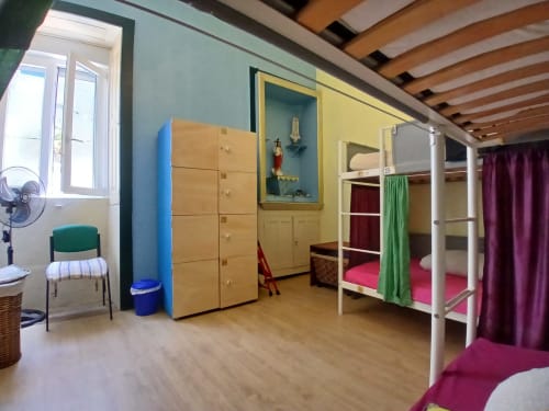 Bright female dormitory room at Bom Caminha hostel in Caminha with bunk beds, wooden storage, and colorful decor