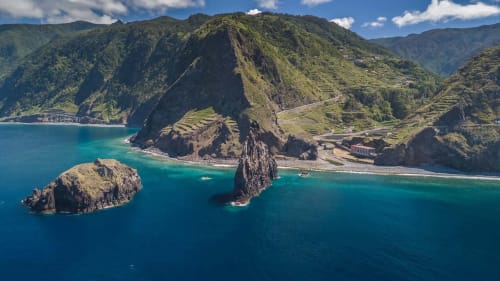 Vista aérea dos penhascais de Porto Moniz, águas turquesas e montanhas verdejantes na Madeira, Portugal