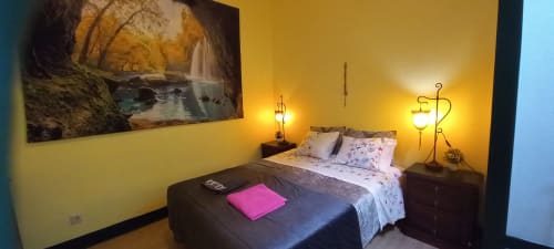 Chambre double confortable à l'auberge Bom Caminha à Caminha avec murs jaune chaud, éclairage lampe et tableau cascade