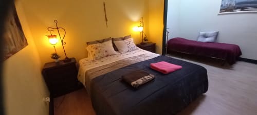 Chambre double à l'auberge Bom Caminha à Caminha avec mur d'accent jaune, lit, lampe de chevet et parquets