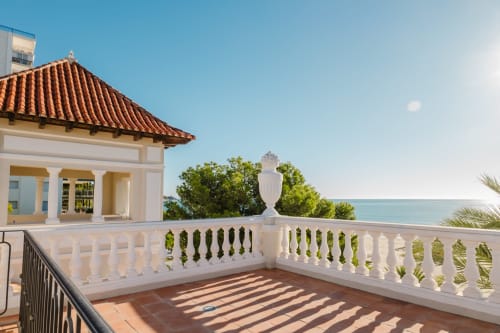 Terraza de Villa María con vista al mar en Benicasim, barandilla blanca, tejado de barro y costa mediterránea