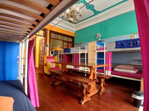 Dortoir mixte coloré de 12 lits au auberge Bom Caminha à Caminha avec lits superposés en bois, murs vibrants et espace commun