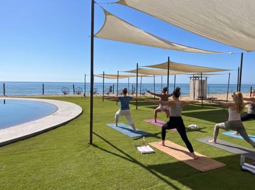 Outdoor yoga class at Vidasoul beachfront property in La Vinorama, Mexico with ocean views and shade sails