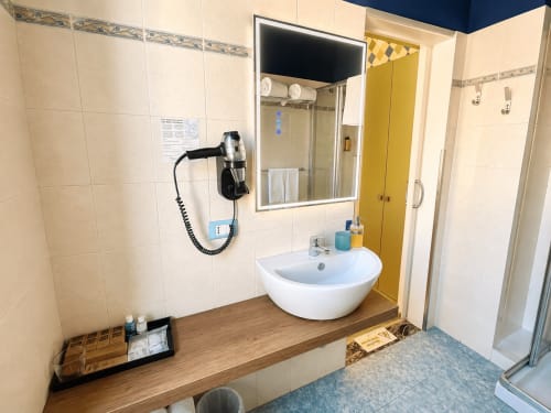 Bagno moderno in Camera Gabbiano al B&B Pellicano, Reggio Calabria, con lavabo curvo, box doccia e mobiletto a muro