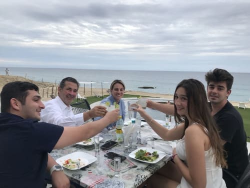Group of friends toasting at beachfront dining table at Vidasoul in La Vinorama, Mexico