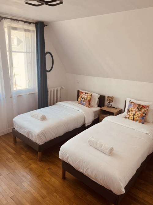 Chambre twin à la villa Cassinne à Montebourg, France, avec literie blanche et coussins colorés