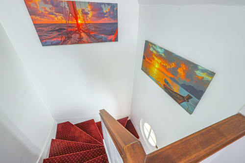 Escalier de La villa Cassinne avec tapis à motifs rouges, rampe en bois et tableau voilier au coucher du soleil à Montebourg