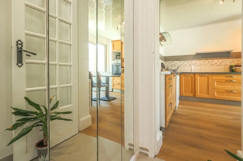 Cuisine moderne avec armoires en bois et électroménagers en acier inoxydable à La villa Cassinne BnB à Montebourg