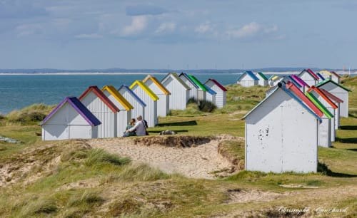 Des cabines de plage colorées bordent les dunes de sable face à la mer près de Carteret, Montebourg, France