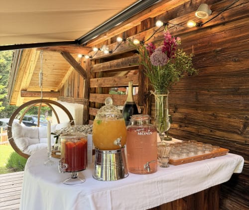 Station de boissons élégante à La Ferme 1828 avec champagne, cocktails et fleurs fraîches dans une grange rustique