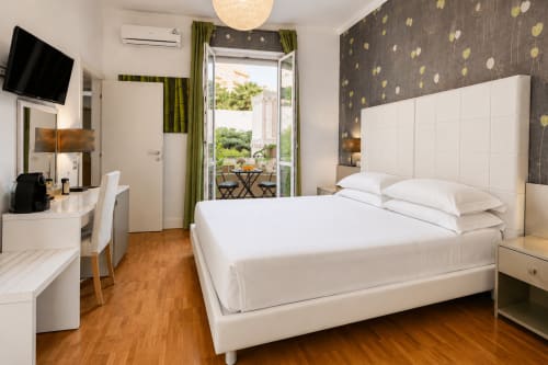 Elegante camera deluxe con letto matrimoniale, mobili bianchi e vista dal balcone - B&B Pellicano Guest House, Reggio Calabria