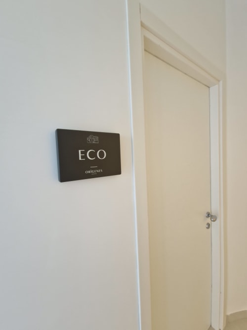 Insegna di ingresso alla camera ECO dell'hotel boutique Origenes Rooms a Procida, Italia con porta color crema