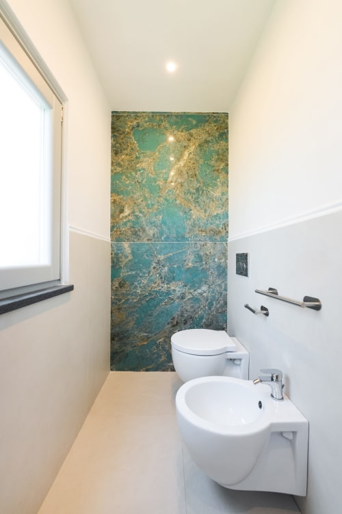 Bagno moderno presso Origenes Rooms, Procida con sanitari bianchi e parete in marmo turchese