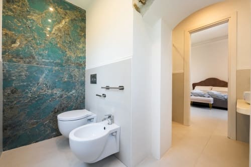Bagno moderno con parete in marmo turchese, sanitari bianchi e bidet presso Origenes Rooms Procida