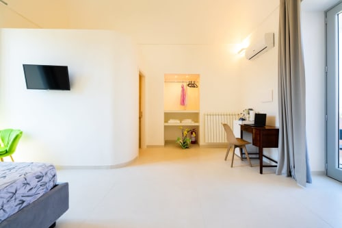 Camera moderna presso Origenes Rooms, Procida con letto, scrivania, TV a schermo piatto e accesso alla vista mare